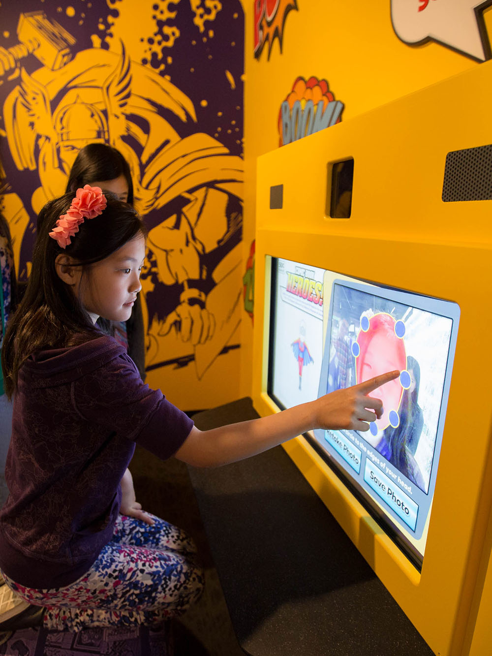 Child touching exhibit screen.