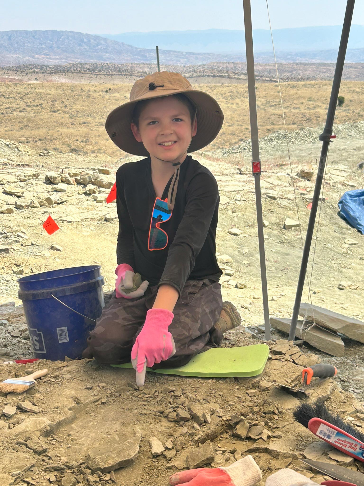 Child showing a fossil discovery on The Jurassic Mile during the Family Dino Dig in Wyoming.