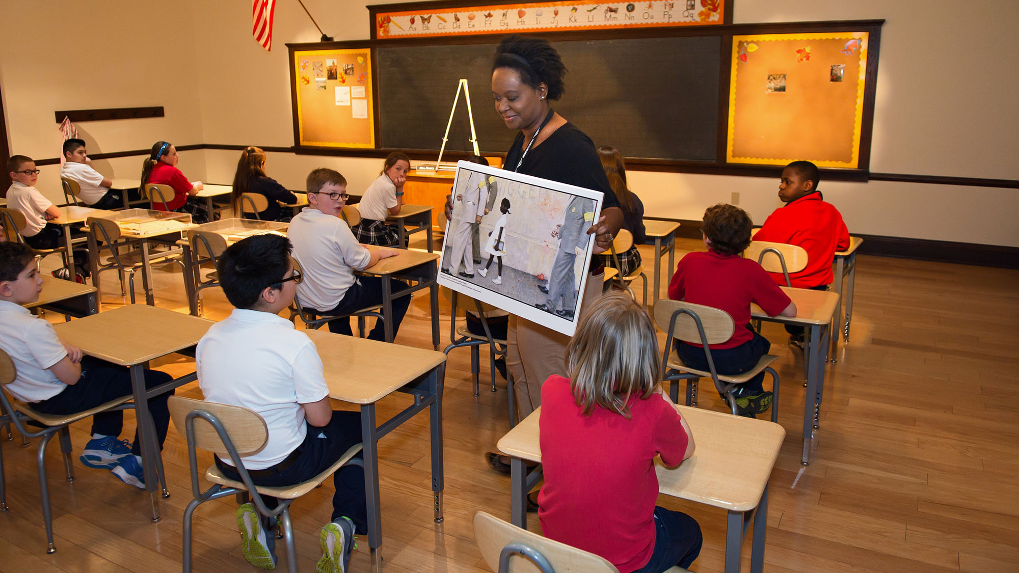 Museum staff member showing children a painting of Norman Rockwell's 