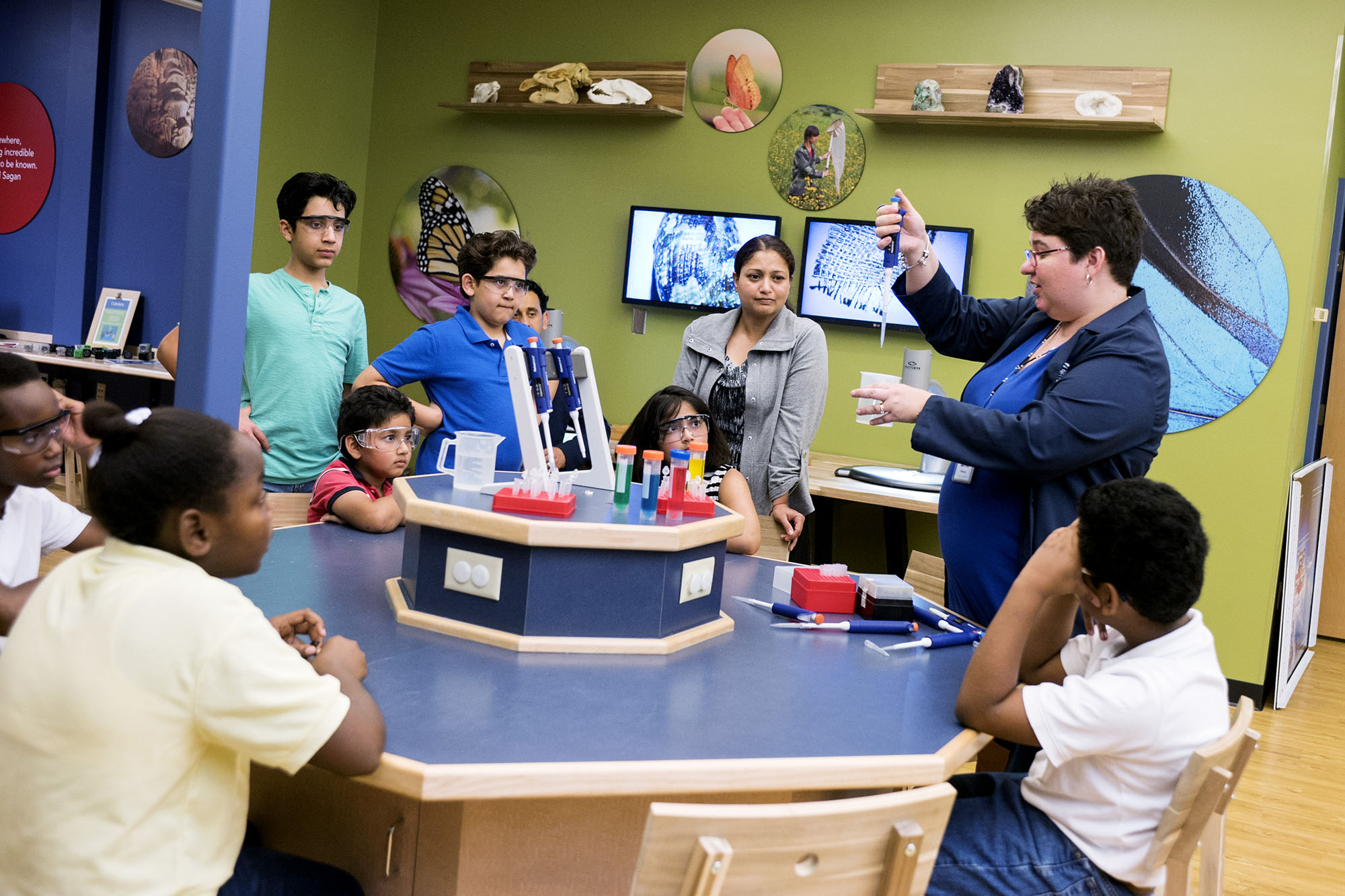 Scientist showing a group of children experiment results.