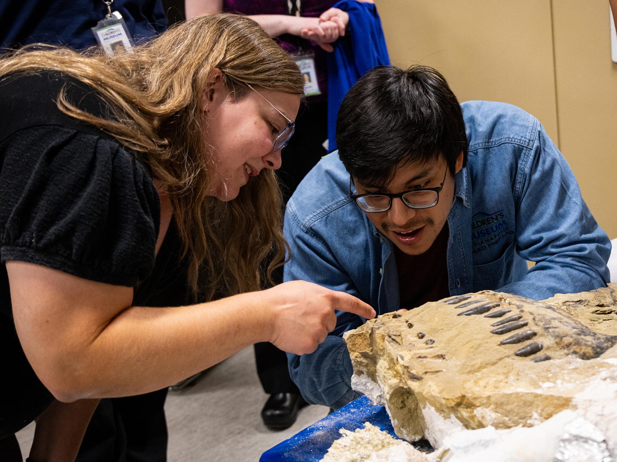 Paleontologists taking a close look at the Allosaurus snout fossil inside the Paleo Lab.