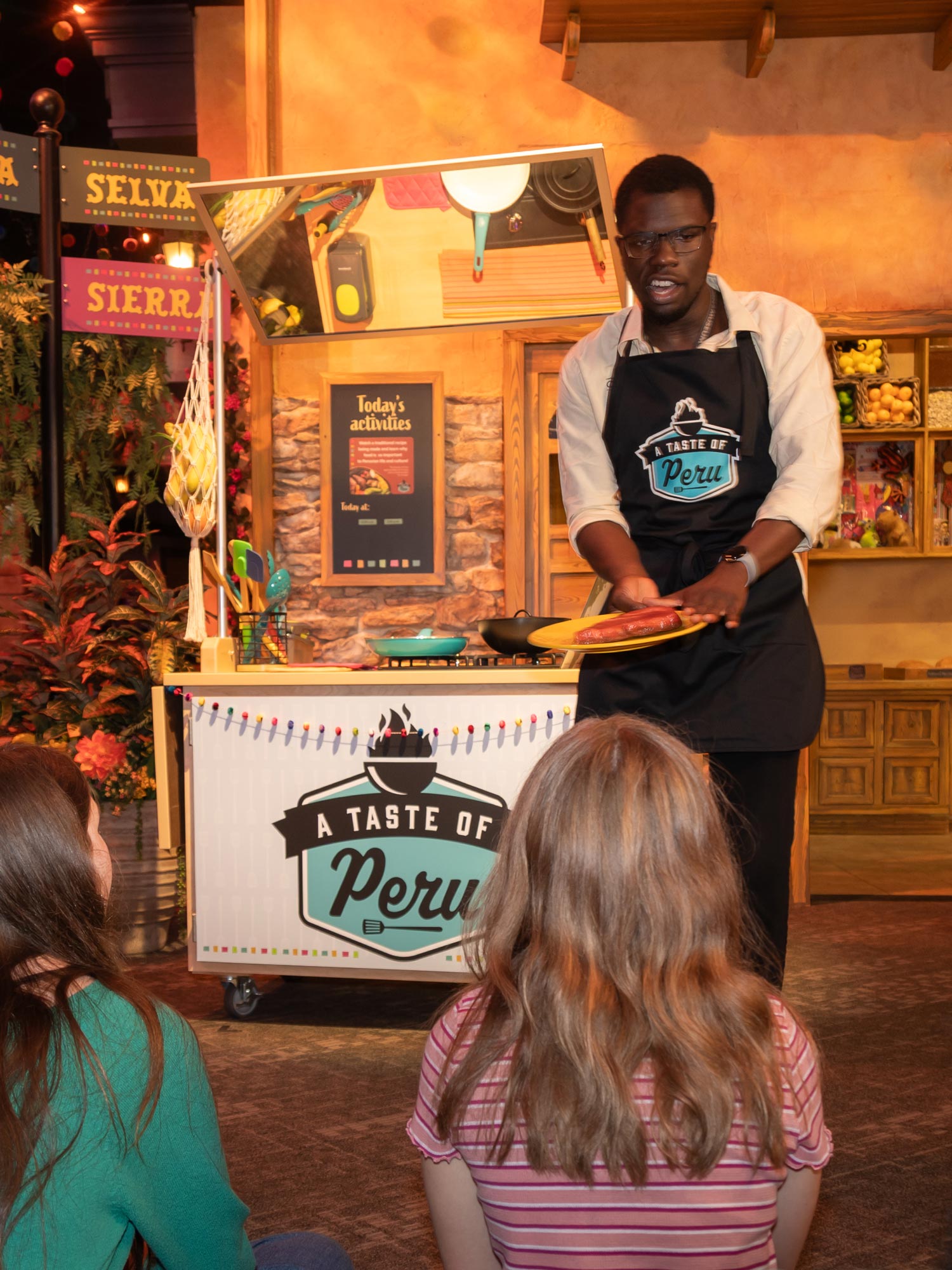 Staff member showing examples of Peruvian food to audience.