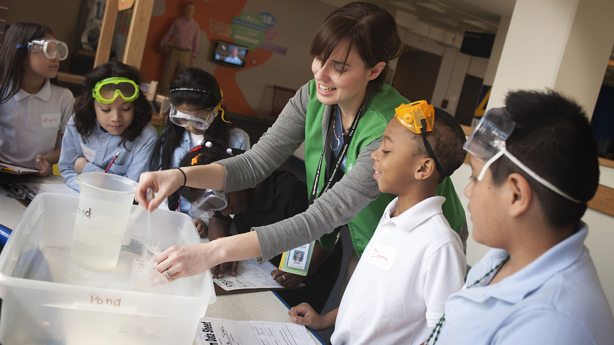Volunteer showing science experiment to a group of kids.